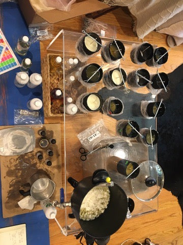 Workbench with various items including bottles, a clear plastic organizer, and tools on a wooden surface.