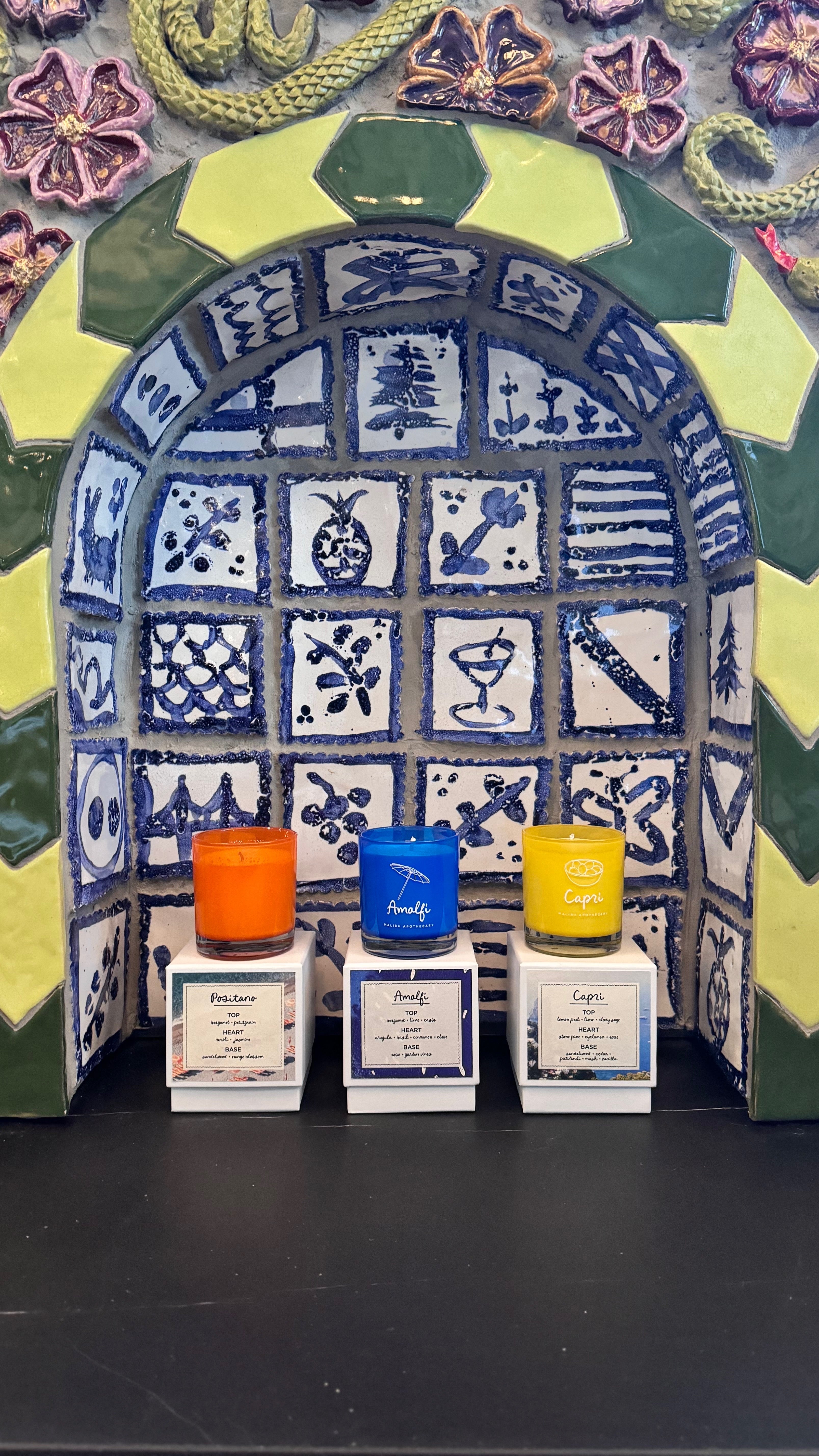 Positano, Amalfi and Capri candles on white blocks in ornate Mediterranean tiled alcove, crafted with natural coconut soy wax