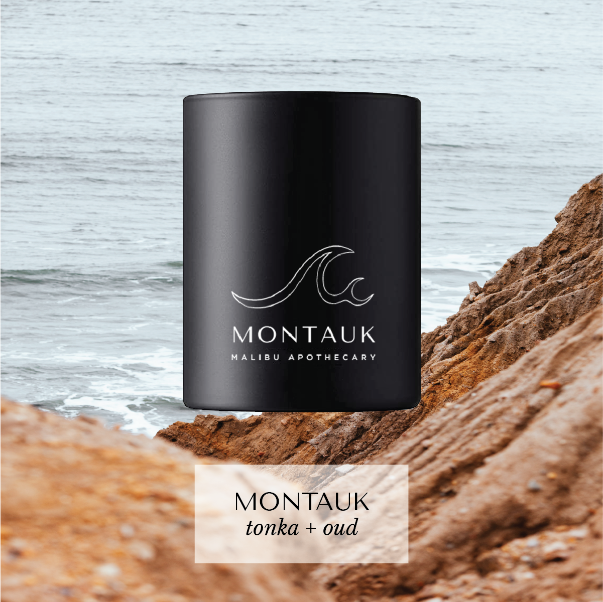 Montauk votive candle with wave logo and tonka-oud scent on rocky coastline with ocean backdrop, hand-poured with coconut and soy wax.
