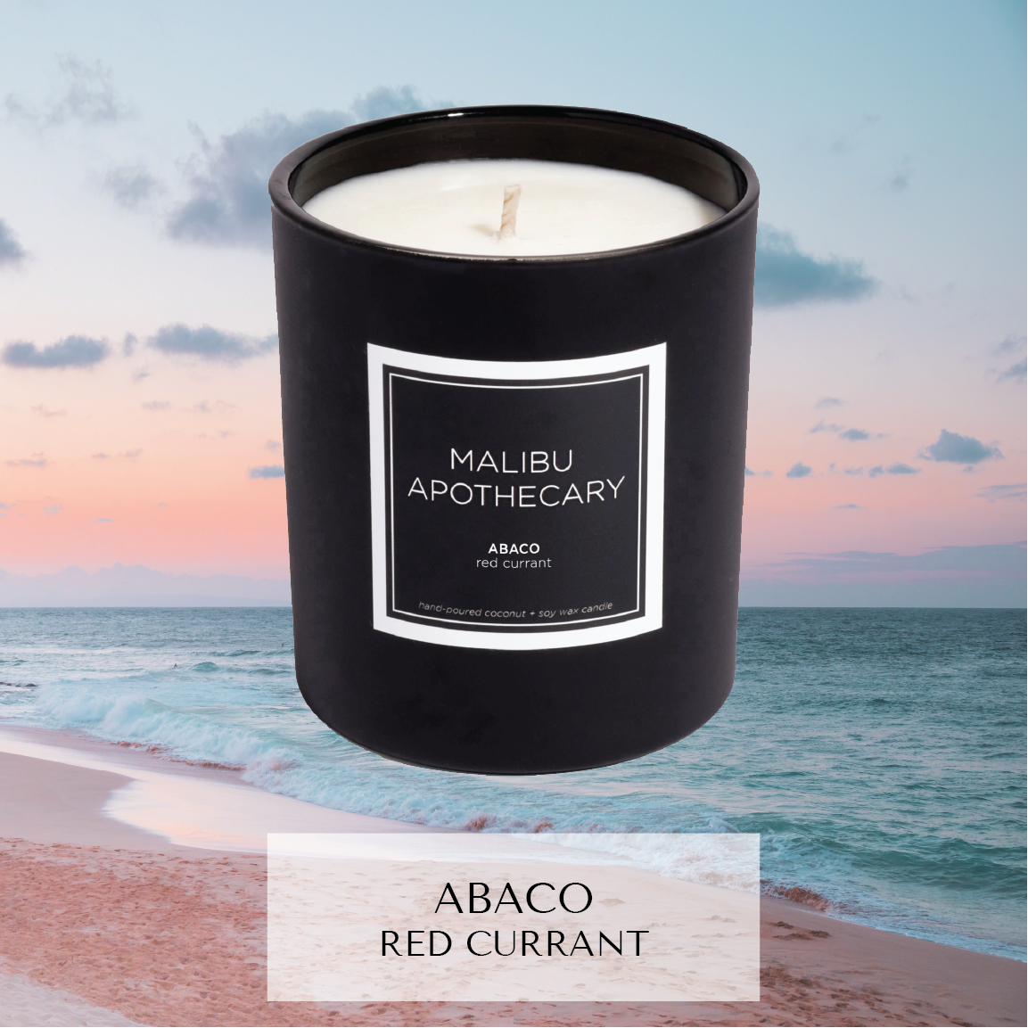 Matte black Malibu Apothecary candle labeled Abaco red currant set against a tranquil pink sunset with turquoise ocean waves, made with all natural coconut and soy wax