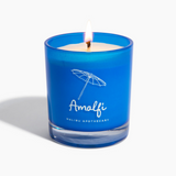 Amalfi bright navy blue glass candle lit with a white backdrop and notes of basil and arugula