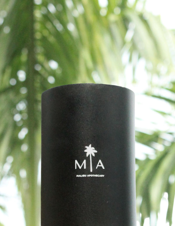 AirScent Mini diffuser using nebulizing technology that atomizes scents into the air placed in front of a palm tree in the British virgin islands