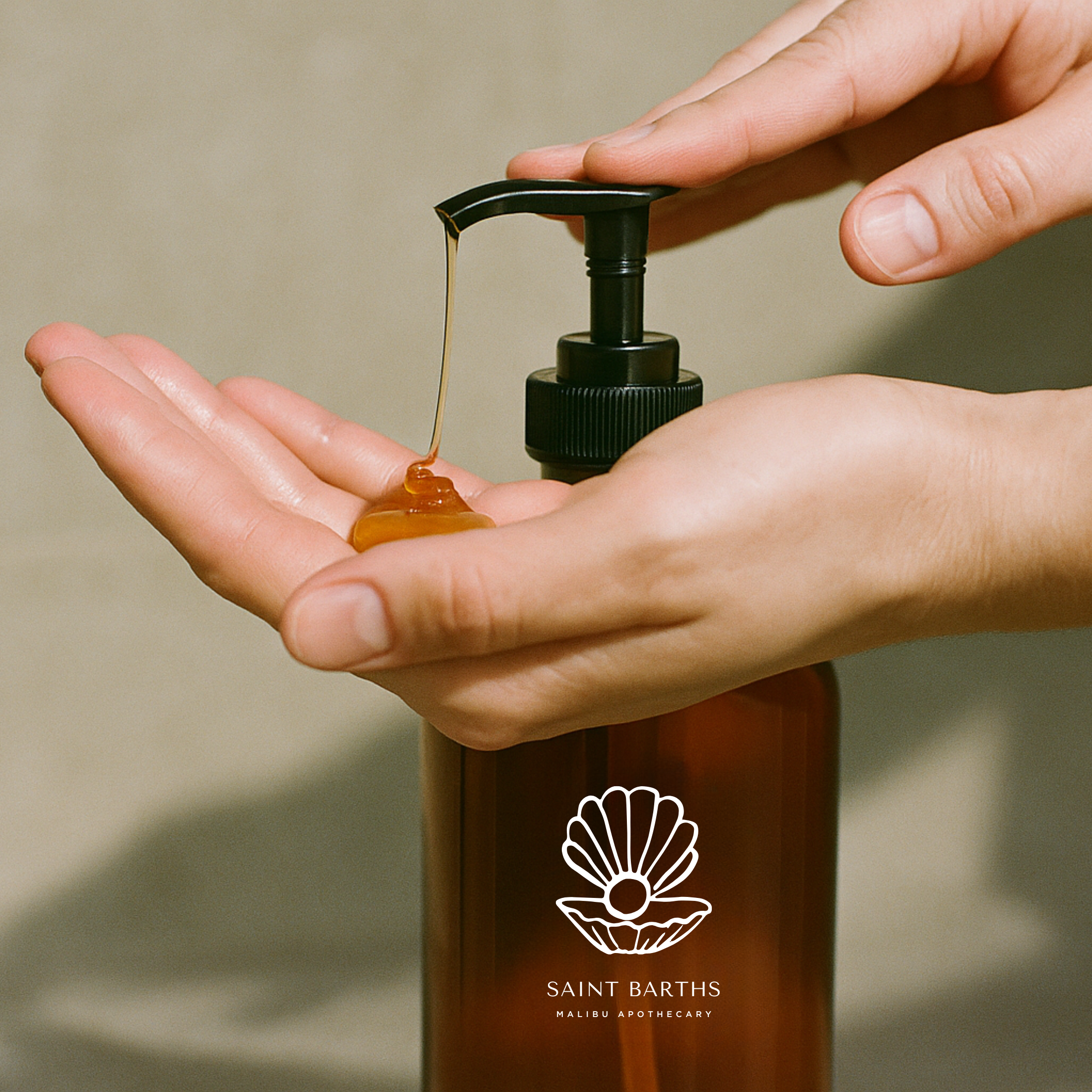 Malibu Apothecary Saint Barths hand wash liquid soap being dispensed from an amber pump bottle into an open palm; luxury nourishing hand wash