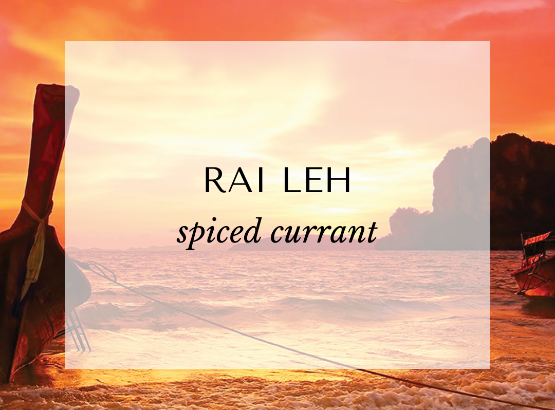 Rai Leh spiced currant fragrance card with bergamot, cassis, white rose, black currant, oak, tonka, and musk — a warm fruity floral perfume inspired by Thai sunsets.