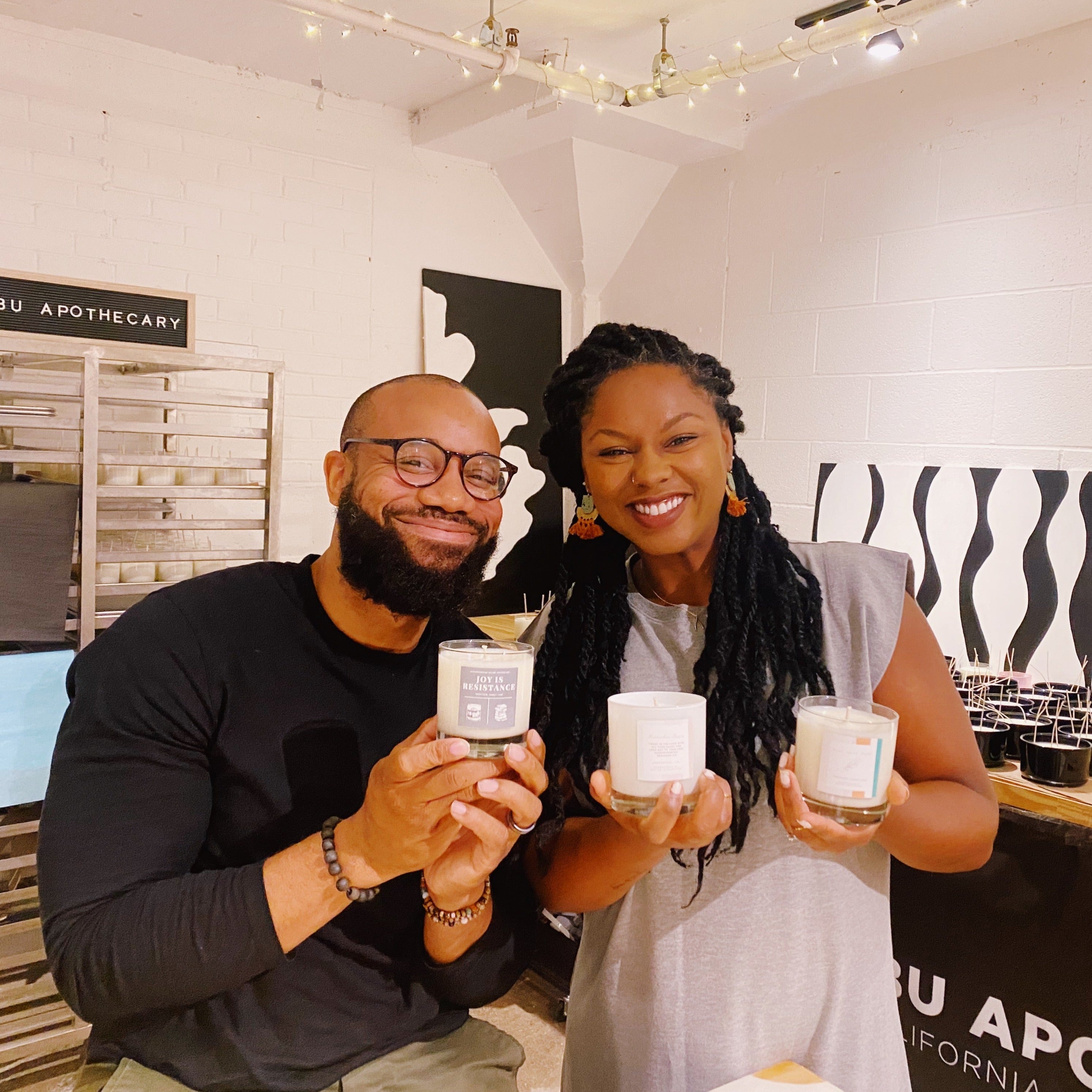 A couple holding three custom candles 