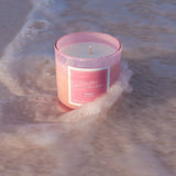 Iridescent pink candle in the pink sands of Eleuthera, Bahamas with the waves crashing in