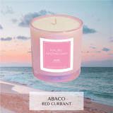 Abaco, red currant scented candle in iridescent pink in front of sunrise