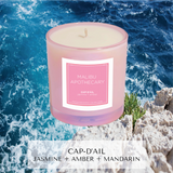 Jasmine, amber, mandarin scented candle inspired by Cap-d'Ail in Iridescent Pink in front of Mediterranean sea rocky beach